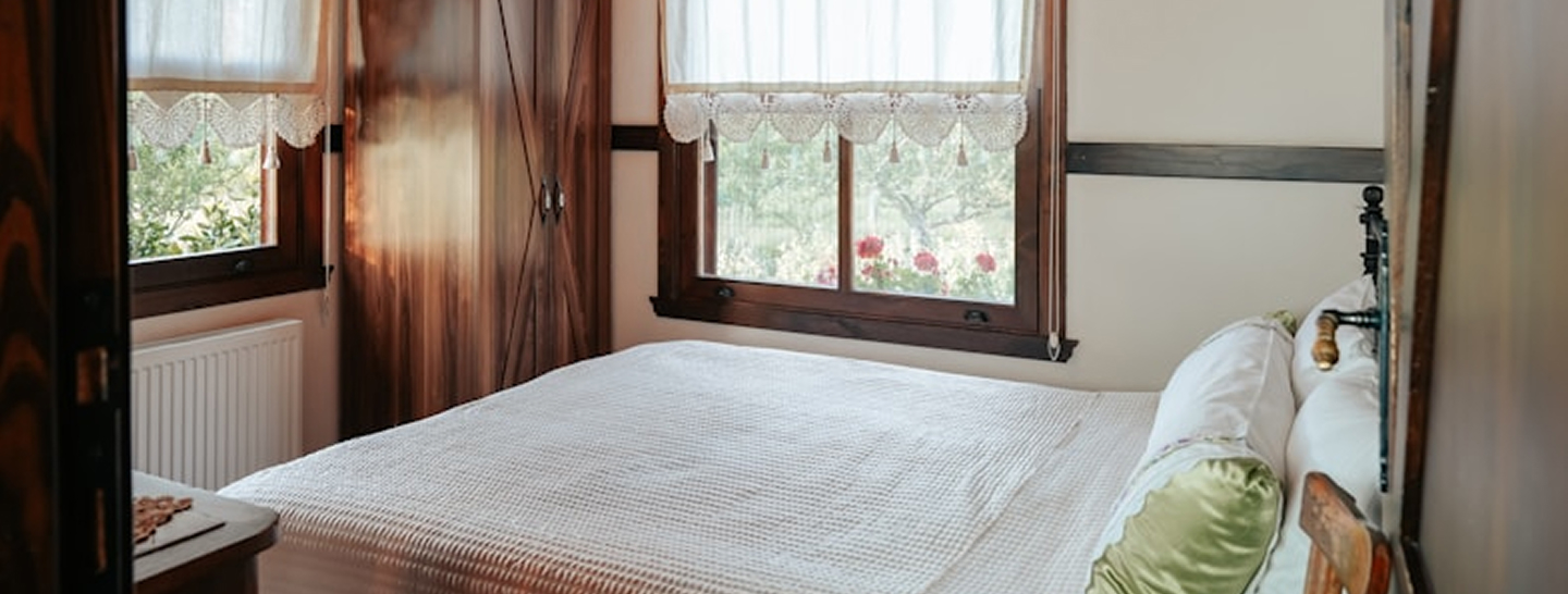 Small bedroom with white walls and wood frames