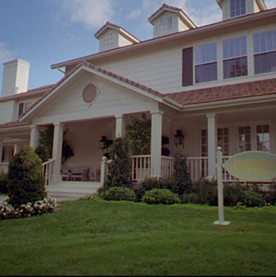 Large white house with a wrap around porch