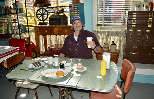 middle aged white man in a blue button up shirt smiling